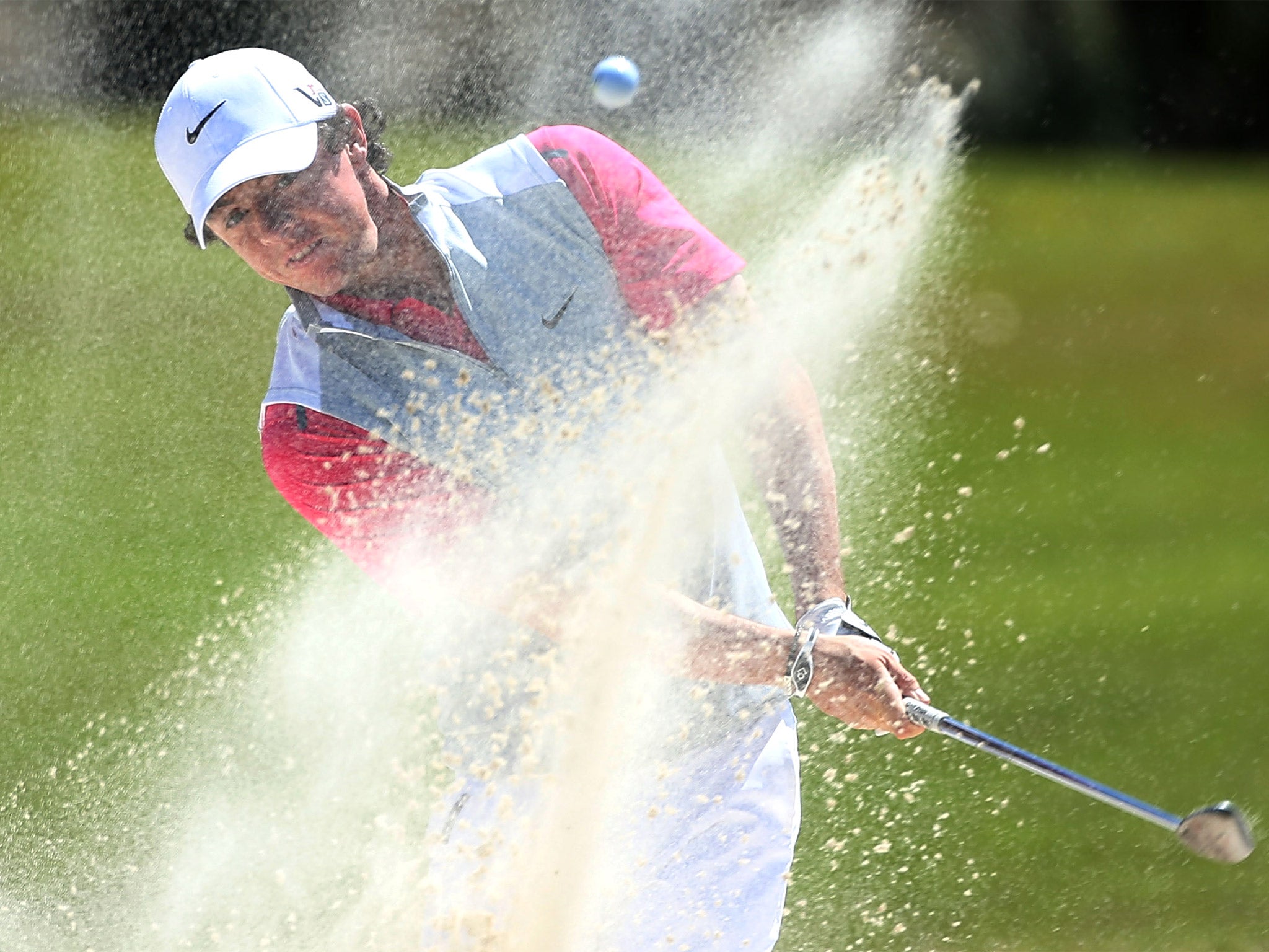 Rory McIlroy blasts out of a sand trap at the 10th hole