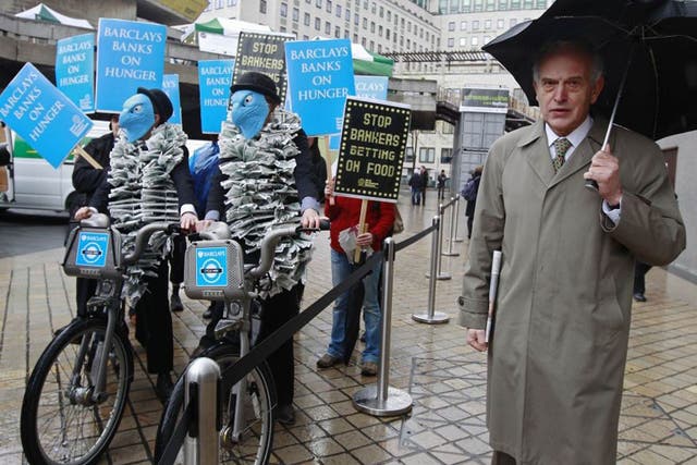 A Barclays shareholder passes demonstrators at the last AGM, where many investors rejected a pay plan