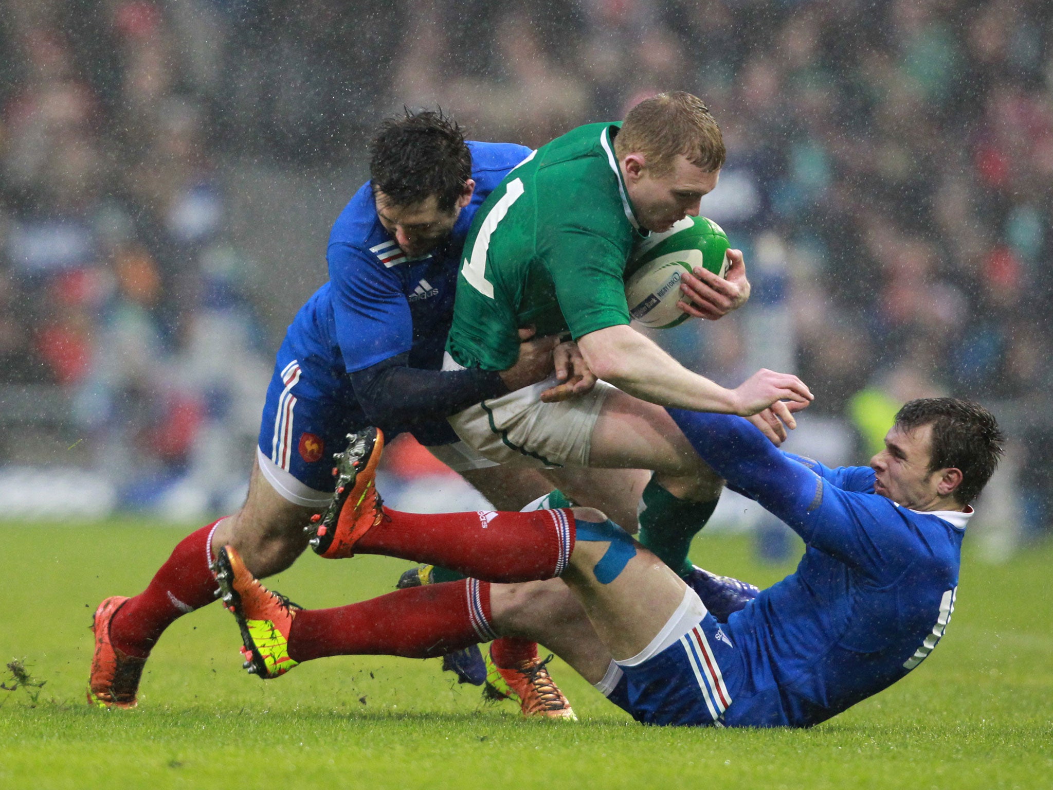 Ireland's wing Keith Earls (C) is tackled by France's wing Vincent Clerc and full back Yoann Huget