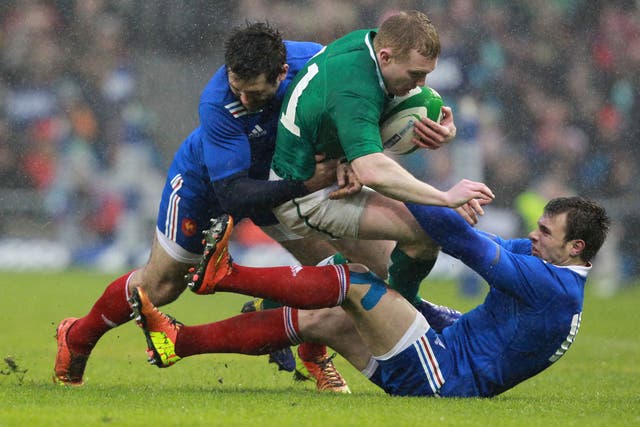 Ireland's wing Keith Earls (C) is tackled by France's wing Vincent Clerc and full back Yoann Huget