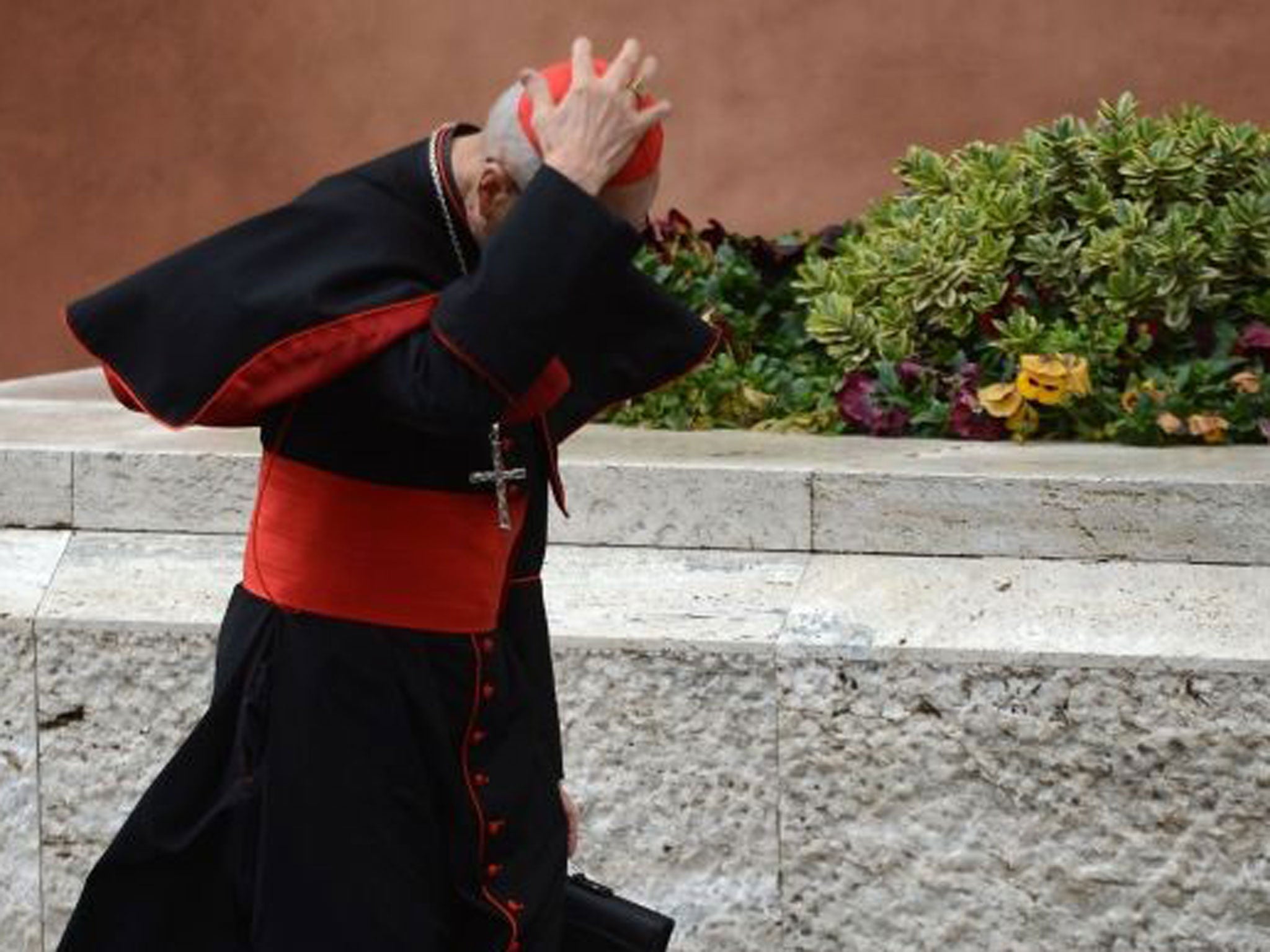 Cross wind: A cardinal arriving for the pre-conclave yesterday, before Tuesday’s vote on the new pope, at the Sistine Chapel