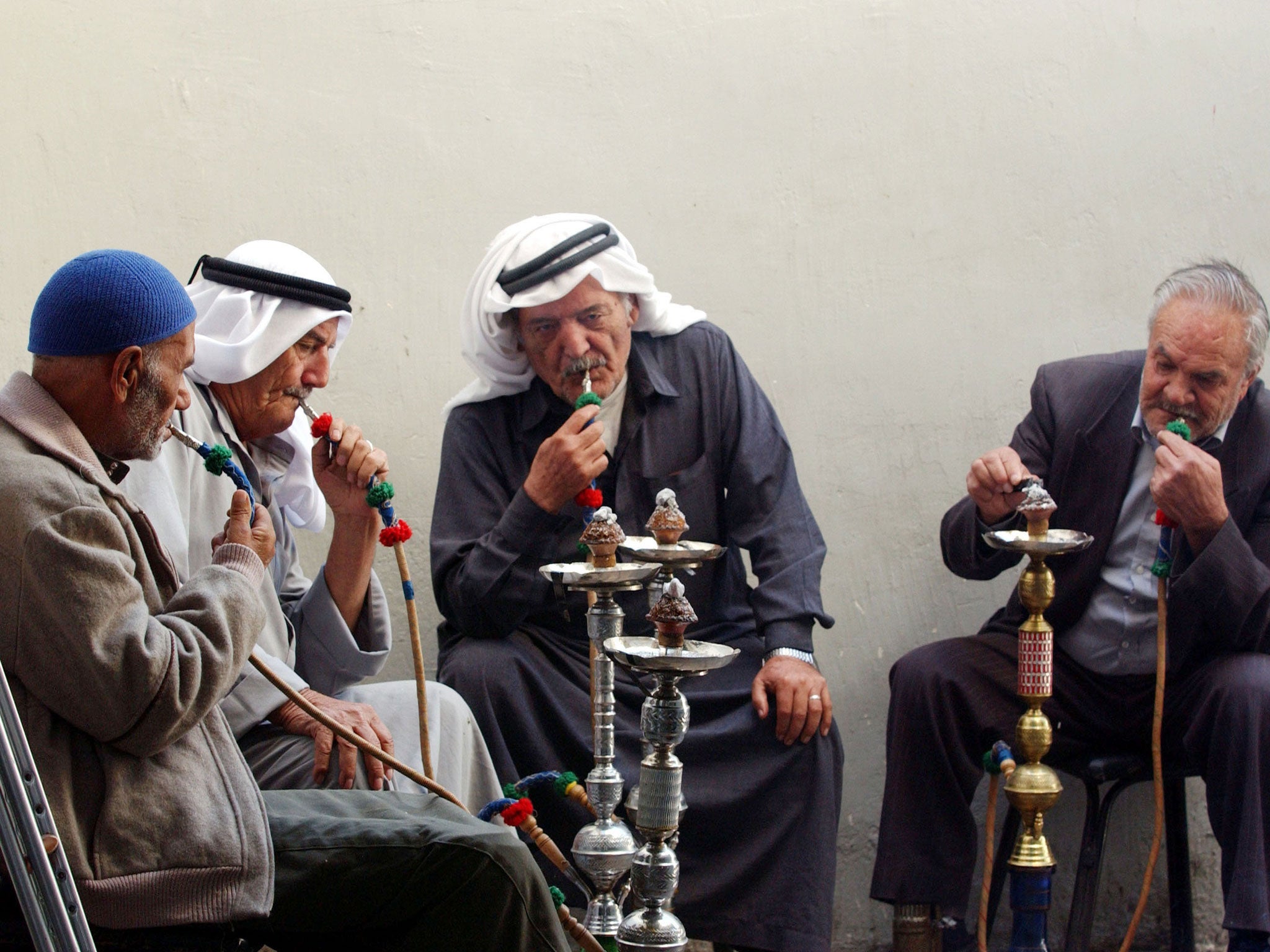 Jordanian men smoke nargile in a cafe October 22, 2002 in downtown Amman, Jordan.