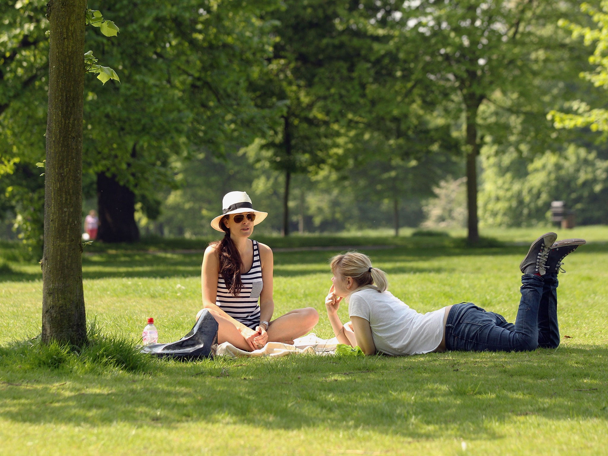 Two women relax in the sunshine in Hyde Park on May 23, 2012 in London, England.