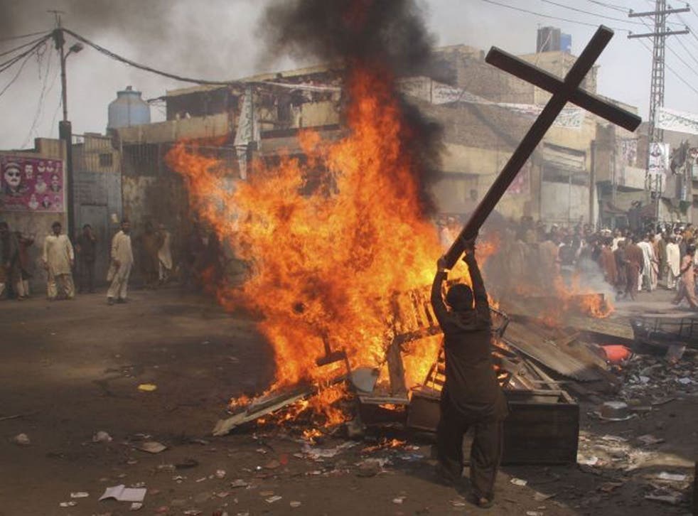 A Muslim demonstrator burns a cross in Badami Bagh on Saturday