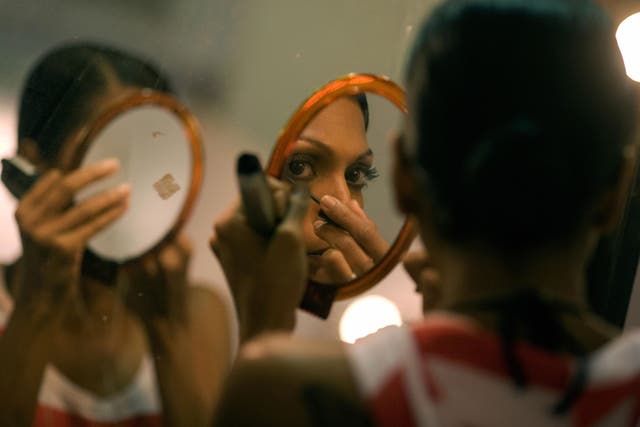 An Indian model is reflected in a mirror as she does her makeup before the Manav Gangwani show at the Wills India Fashion Week (WIFW) at Pragati Maidan in New Delhi on March 15, 2008.