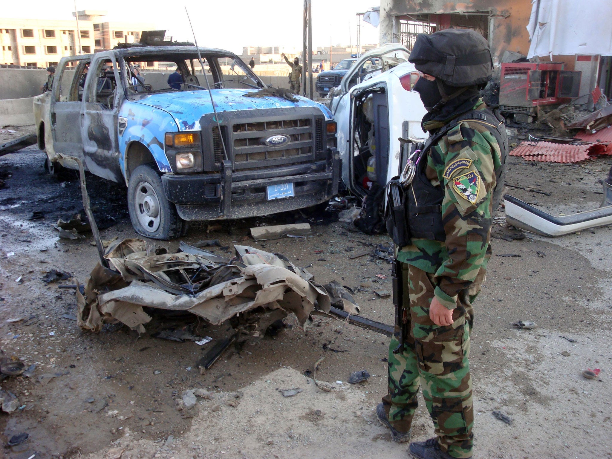 An Iraqi security office stands close to the debris following a car bomb, in the northern city of Kirkuk on March 5, 2013.