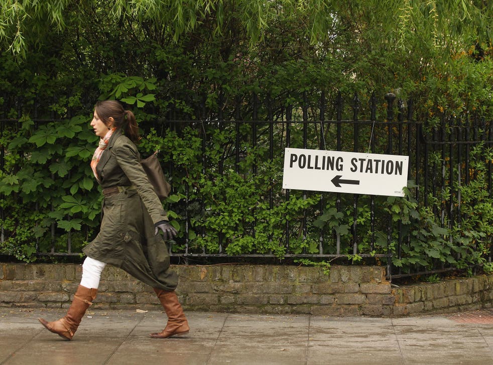 A woman walks past a sign for a polling station in North London as the public votes for the next Mayor of London and in local elections on May 3, 2012 in London, England.