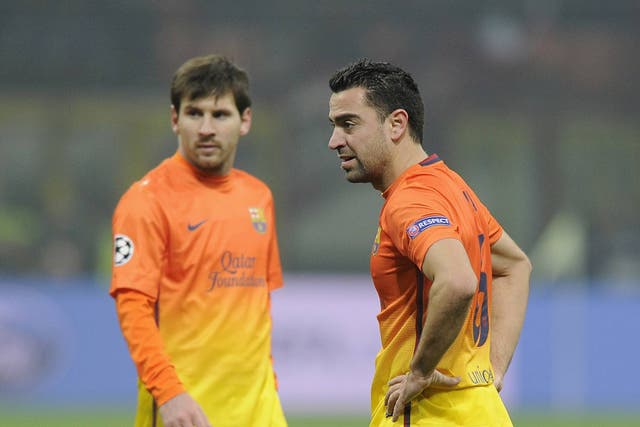 Barcelona duo Xavi and Lionel Messi pictured in the first leg against AC Milan