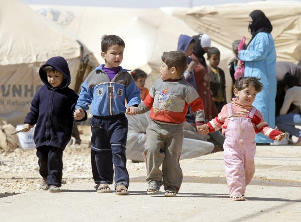 Syrian children walk amid tents at the Zaatari refugee camp in Jordan