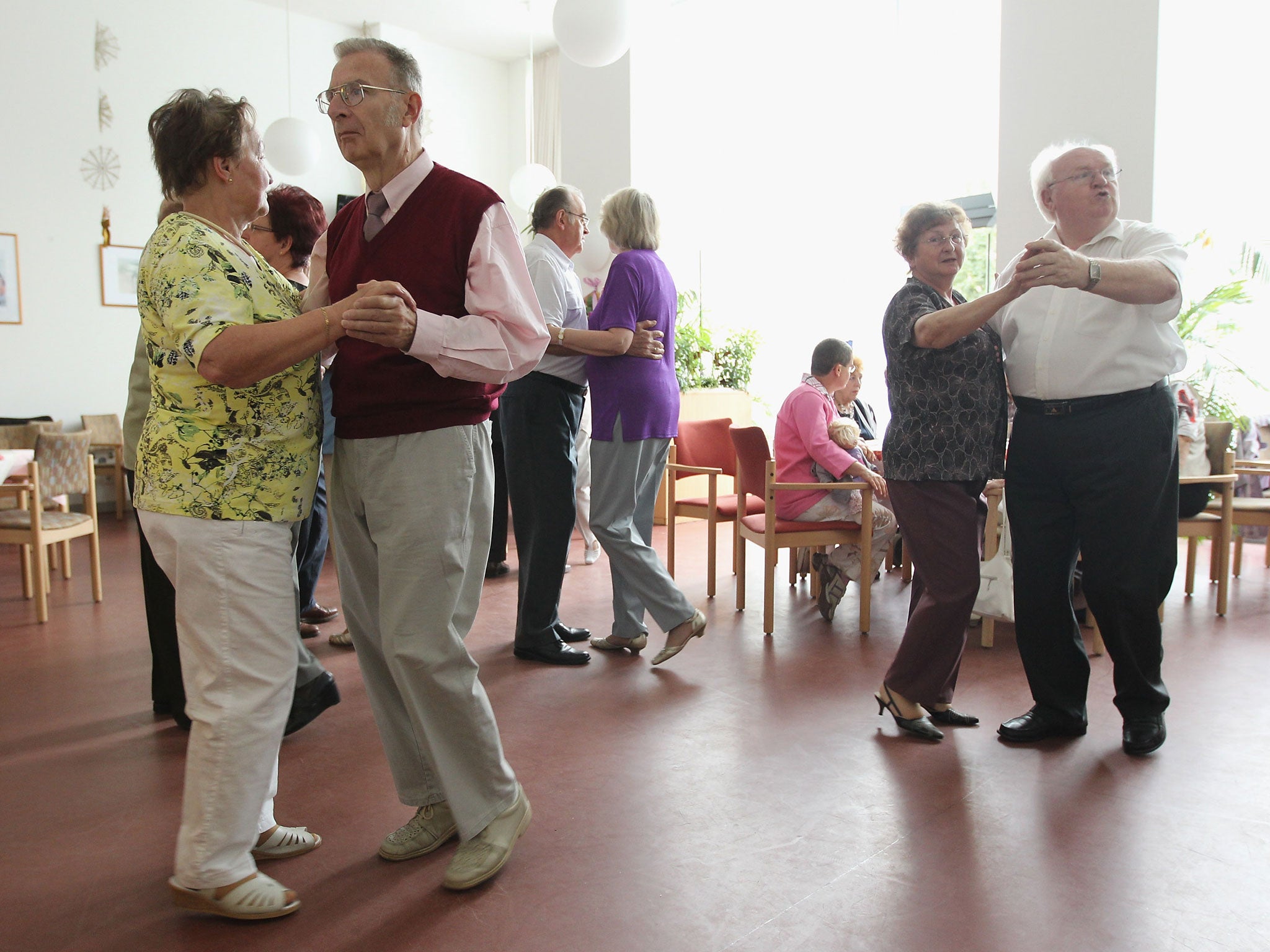 Elderly people dance during an afternoon get-together in the community room of the Sewanstrasse senior care home in Lichtenberg district on August 30, 2011 in Berlin, Germany.
