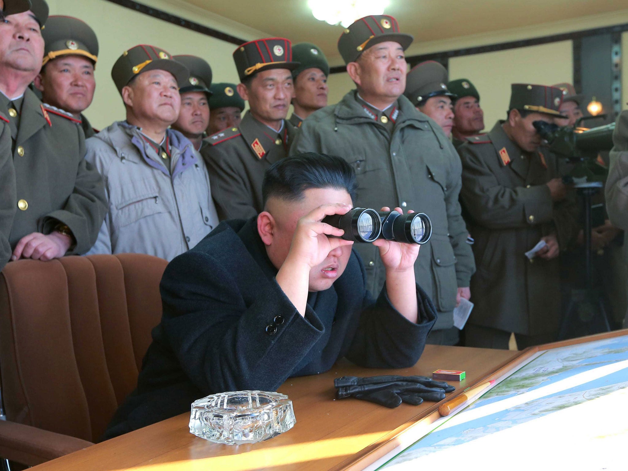 North Korean leader Kim Jong-un (centre) and military officers watching a live shell firing drill