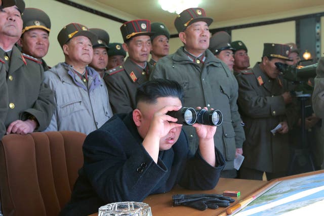 North Korean leader Kim Jong-un (centre) and military officers watching a live shell firing drill
