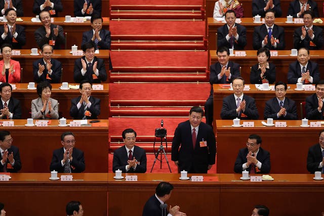Newly elected President Xi Jinping is applauded by delegates