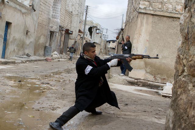 A Syrian rebel aims his weapon during clashes with government forces in the streets near Aleppo international airport in northern Syria on March 4, 2013.
