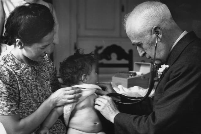 circa 1940: A doctor examining a young patient at a Welfare Centre clinic.