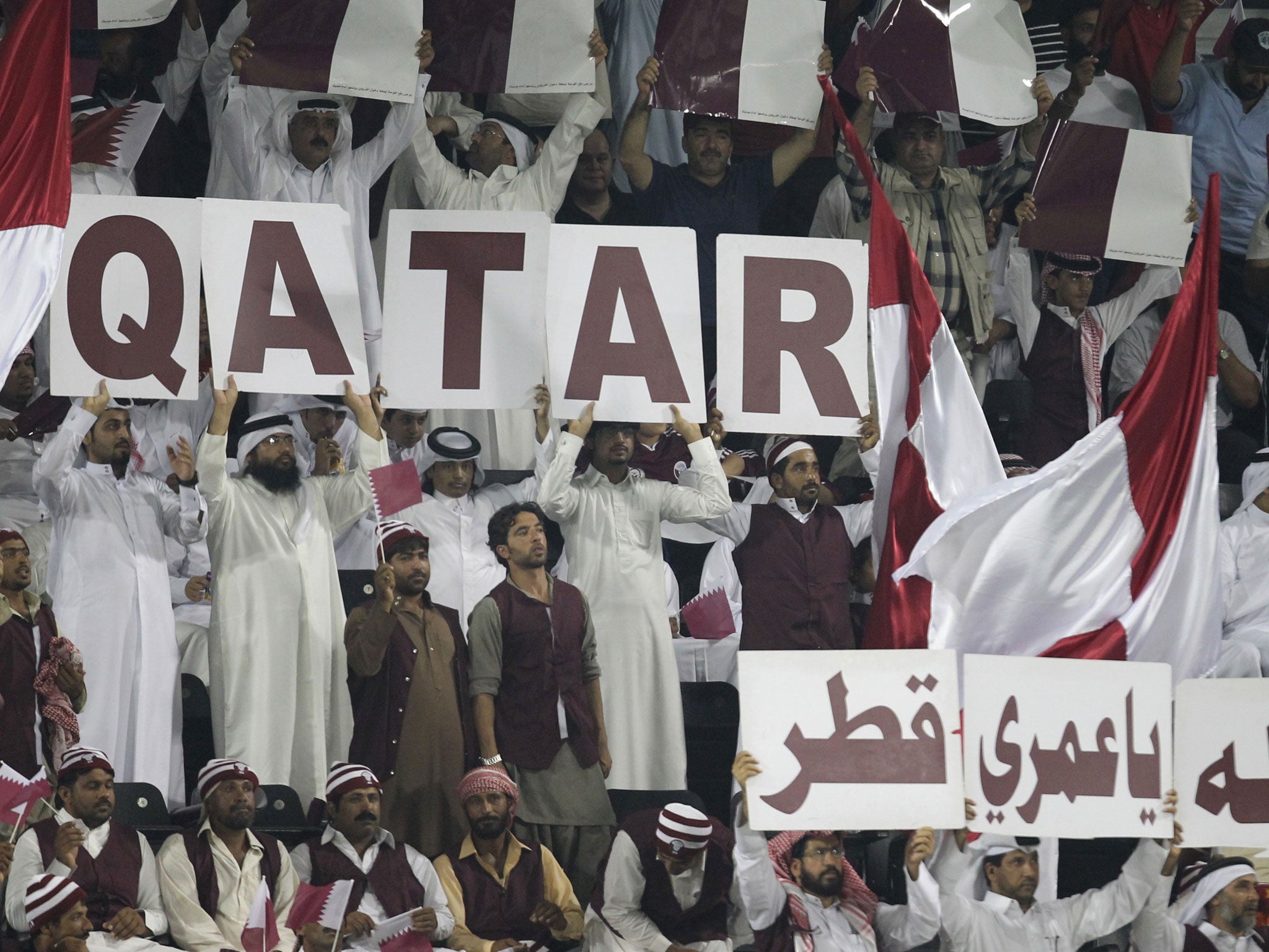 Qatari fans cheer their side on