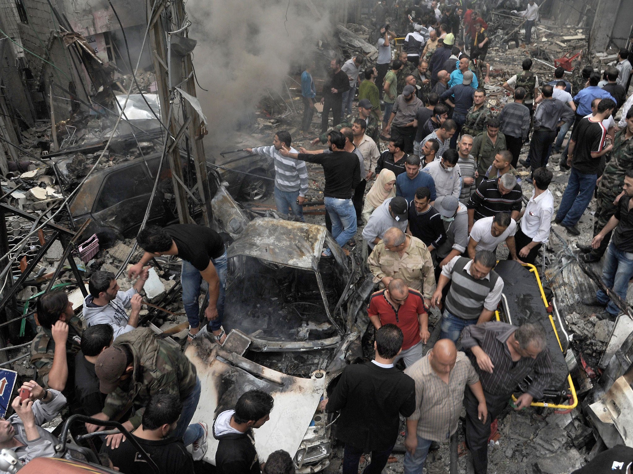 Syrians inspecting the site of an explosion in the Mazzeh district of the capital Damascus.
