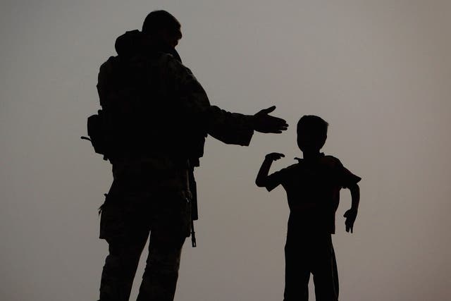 On a mission: A gunner from 15 Sqn RAF, a force protection unit, with a small boy in Basra, 2009