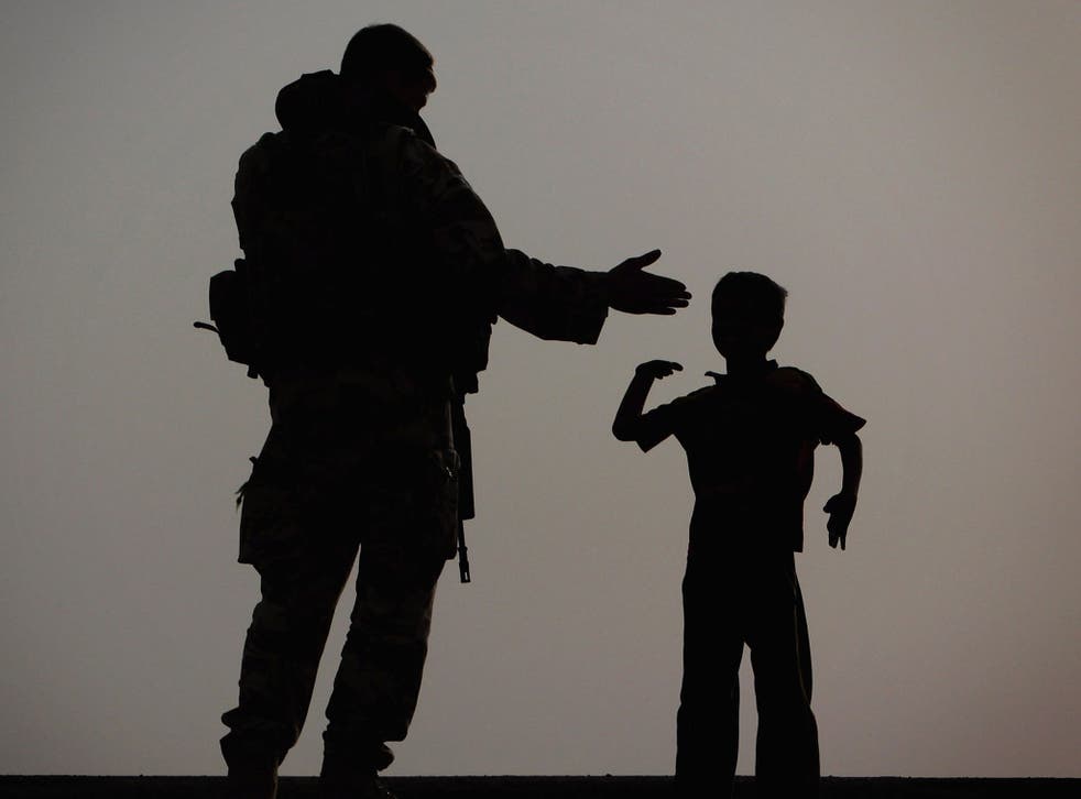 On a mission: A gunner from 15 Sqn RAF, a force protection unit, with a small boy in Basra, 2009
