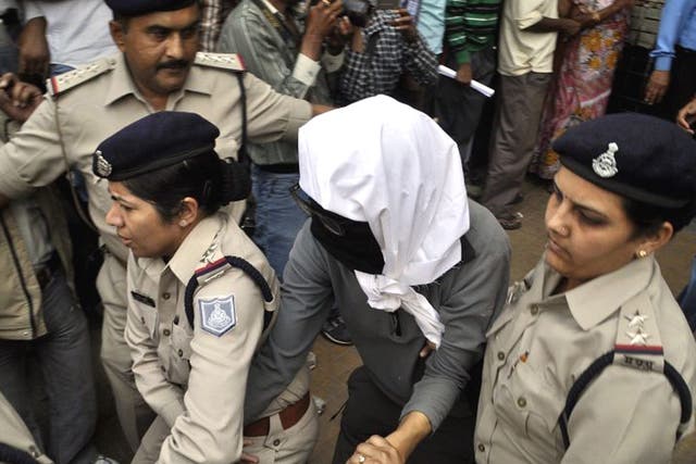 The victim has her face hidden
as she is taken for a medical
examination in Gwalior