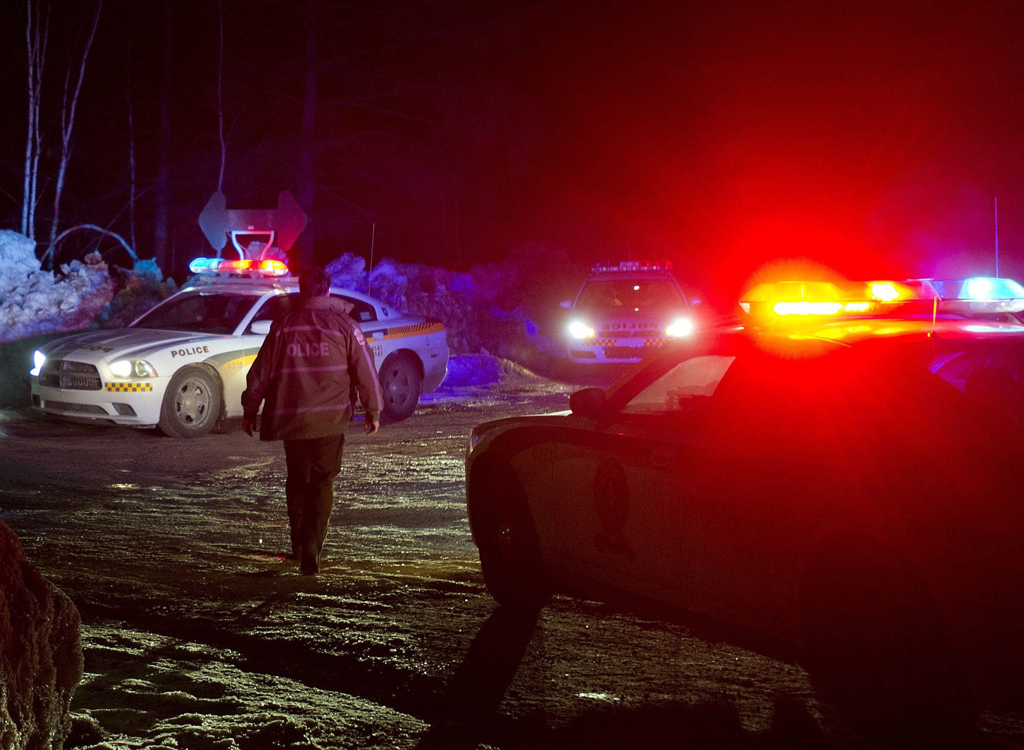 Police vehicles block a road just outside the town of Chertsey, Quebec during the search for the escaped prisoners