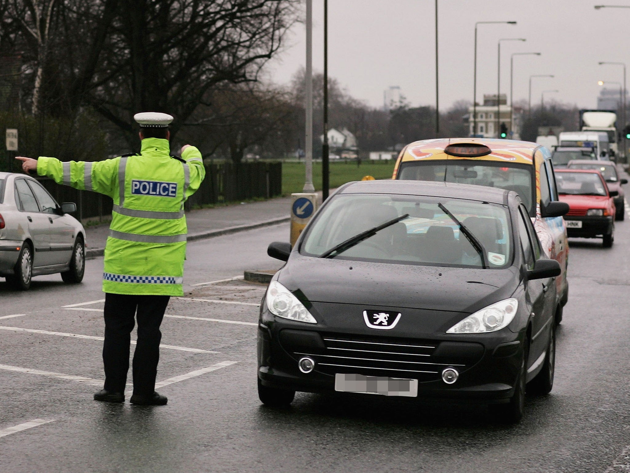 A police pulls a car over as part of a drive to inform motorists of the risk of using a phone while driving