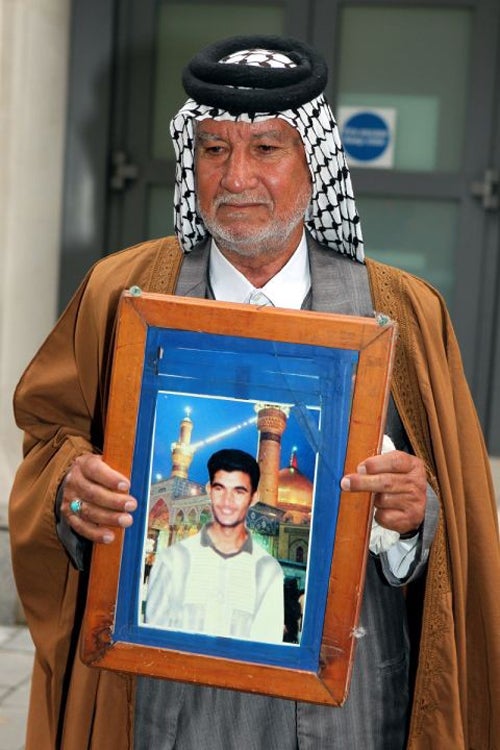 Mizal Karim Al-Sweady, the father of Hamid Al-Sweady, carries a photo of his son after leaving the inquiry into his death