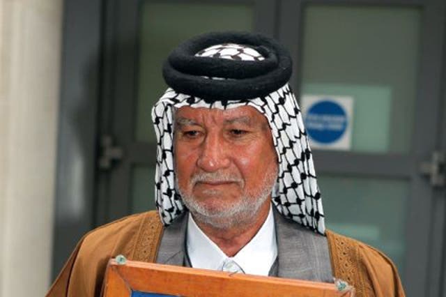 Mizal Karim Al-Sweady, the father of  Hamid Al-Sweady, carries a photo of his son after leaving the inquiry into his death