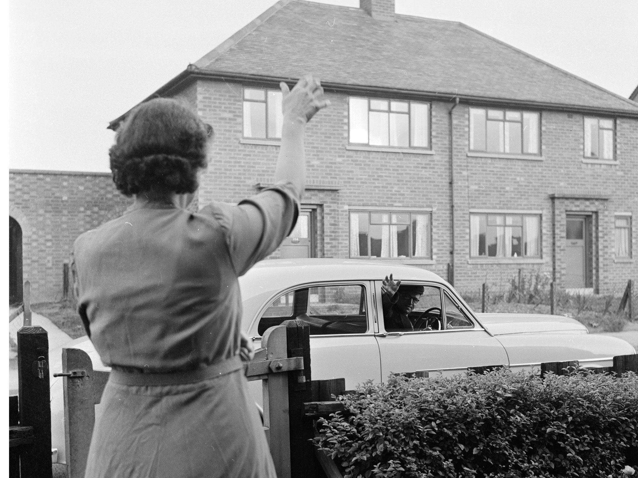 9th November 1956:Bernard Bradbury of Hinckley in Leicestershire waves goodbye to his wife as he leaves for work in his new Wolseley. Mr Bradbury recently won? 15,000 in the Littlewoods pools but has continued to drive a tractor for a local factory.