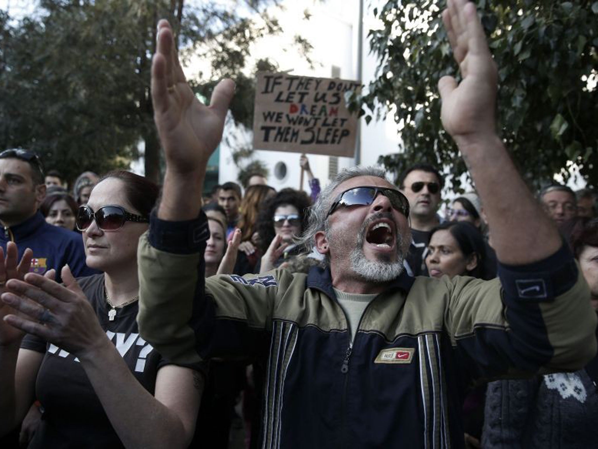 Protesters shout slogans during an anti-bailout rally outside the parliament in Nicosia yesterday