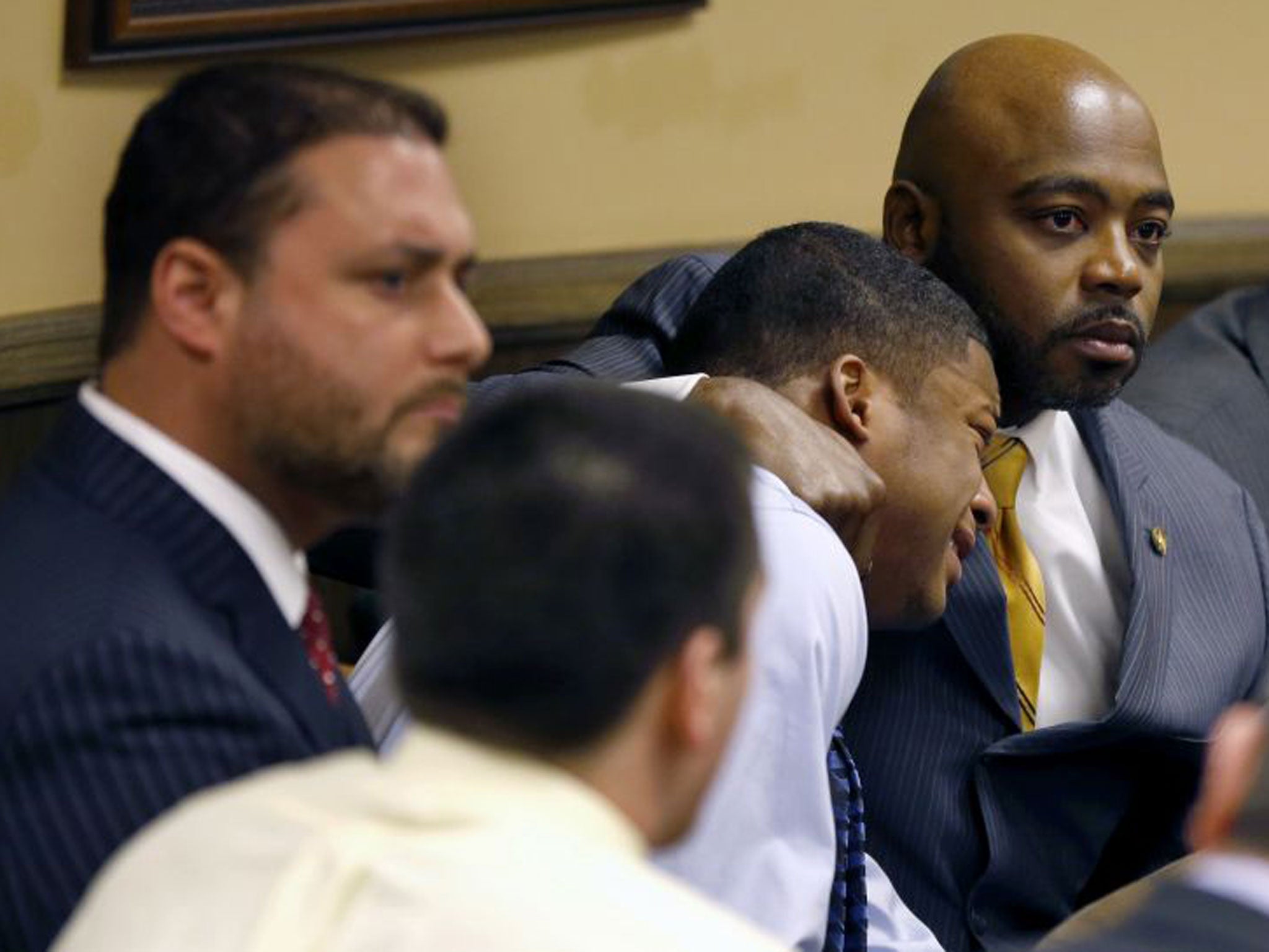 Defense attorney Walter Madison, right, holds his client, 16-year-old Ma'Lik Richmond, second from right, while defense attorney Adam Nemann, left, sits with his client Trent Mays, foreground, 17, as Judge Thomas Lipps pronounces them both delinquent on rape and other charges after their trial in juvenile court in Steubenville, Ohio, Sunday, March 17, 2013. Mays and Richmond were accused of raping a 16-year-old West Virginia girl in August 2012.