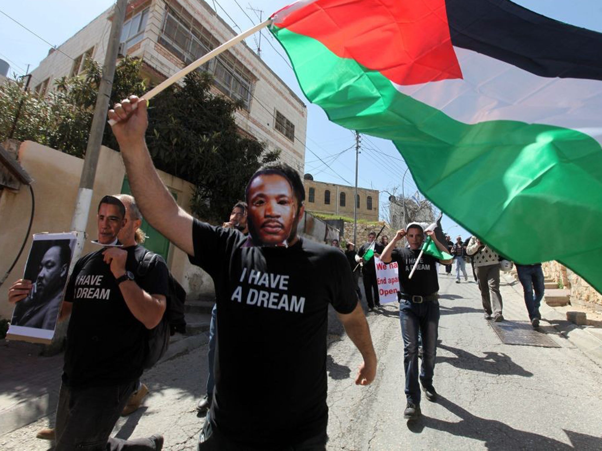 Demonstrators wearing Martin Luther King masks march on Hebron street closed to Palestinians