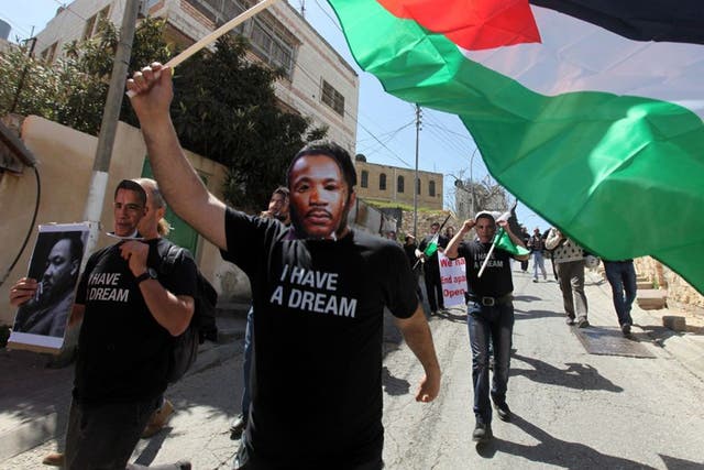 Demonstrators wearing Martin Luther King masks march on Hebron street closed to Palestinians