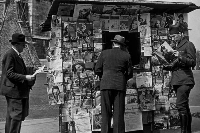 circa 1940: A soldier in Paris reading Picture Post at a newsstand.