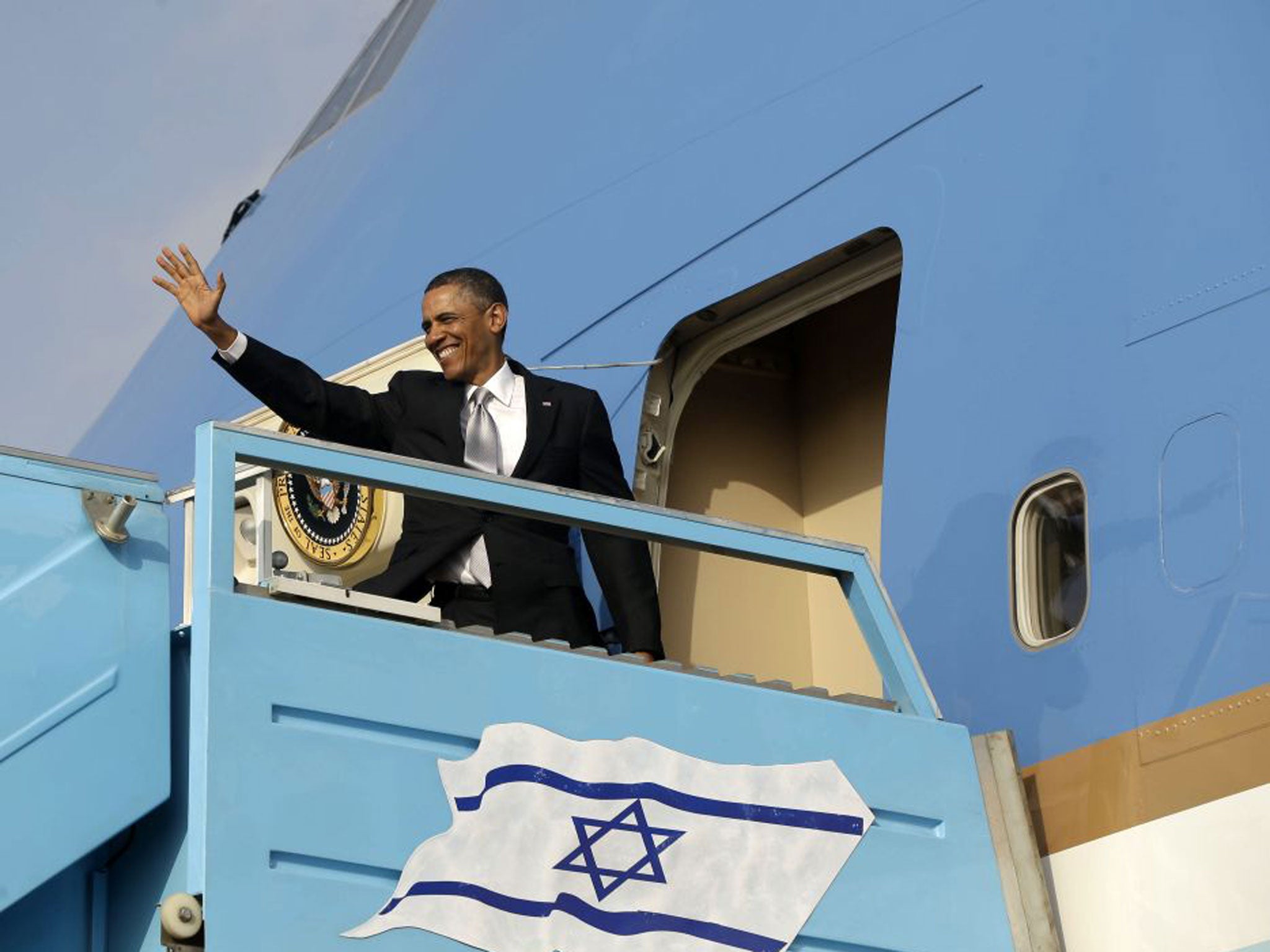 President Barack Obama waves before boarding Air Force One prior to his departure from Ben Gurion International Airport in Tel Aviv