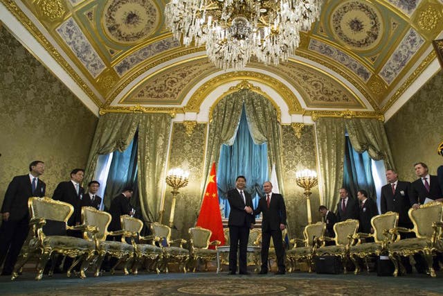 Vladimir Putin and Xi Jinping shake hands in the impressive St George Hall in the Kremlin yesterday