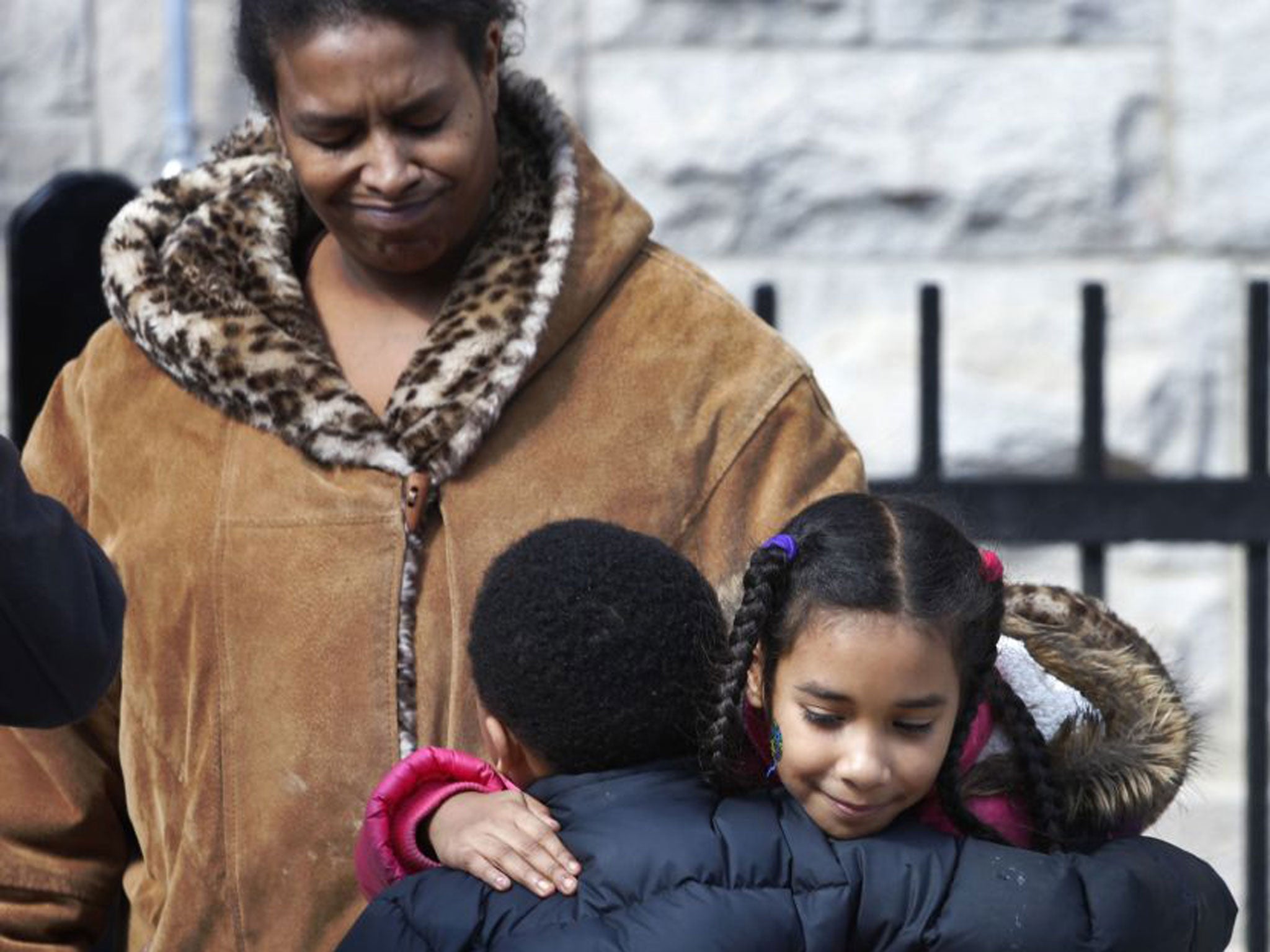 Maria Llanos watches on as her daughter hugs a friend at the soon-to-close Lafayette School in Chicago