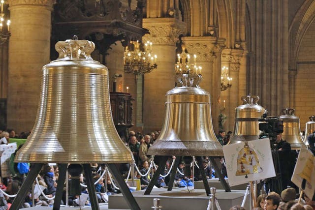 People gather around the new bells of Notre-Dame de Paris Cathedral during their blessing mass