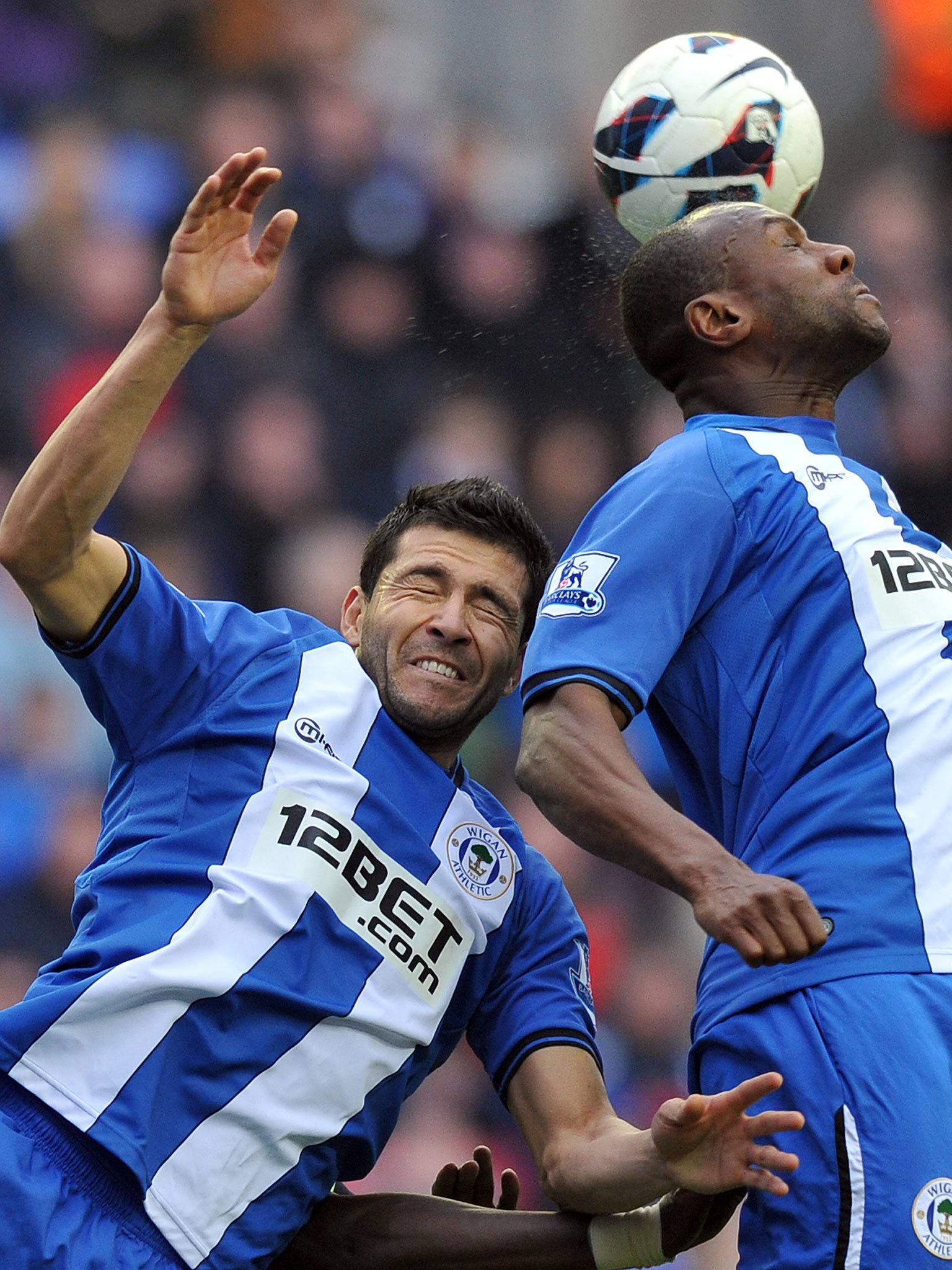 Wigan Athletic's Paraguayan defender Antolin Alcaraz (left) jumps for the ball with Barbadian defender Emmerson Boyce