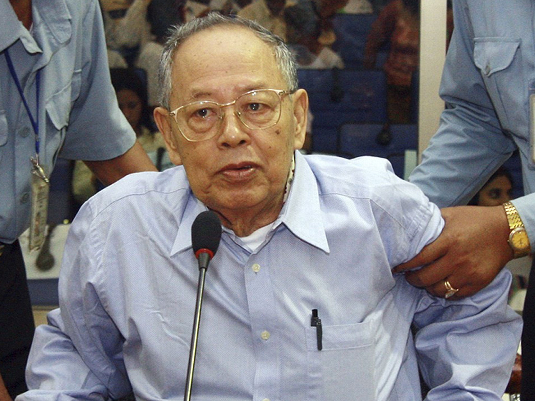 Sary is assisted by guards during hispre-trial hearing in Phnom Penh in 2008