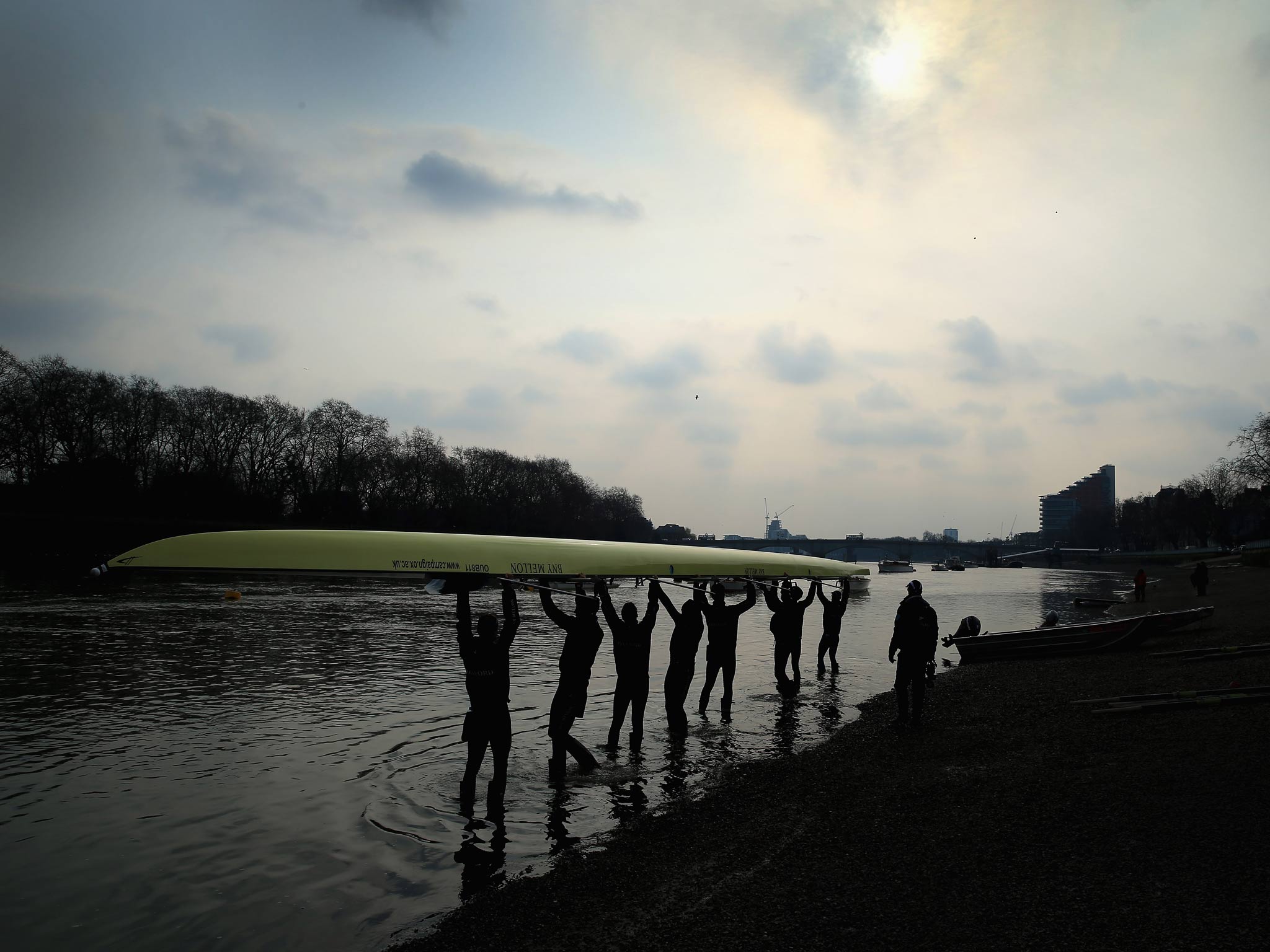 Oxford's Isis crew lift their boat into the water during a training outing on the River Thames ahead of the 159th University Boat Race