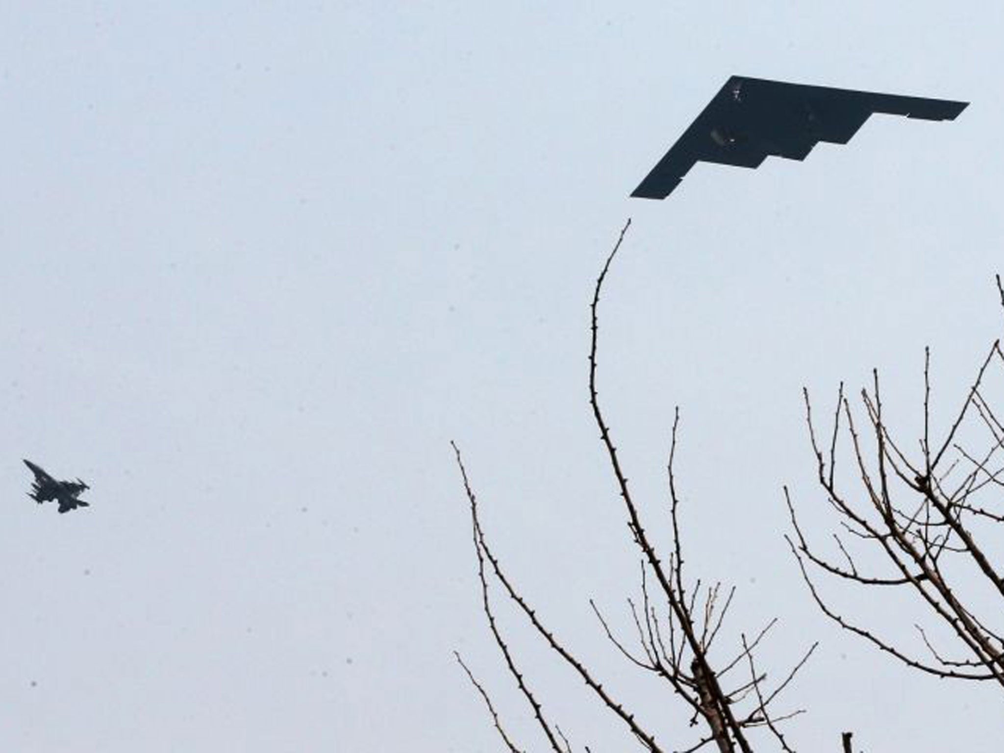 A US B-2 stealth bomber (R) flies over a US air base in Pyeongtaek, south of Seoul