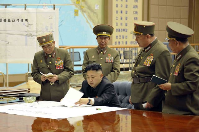 A picture released by the North Korean Central News Agency (KCNA) on 29 March 2013 shows North Korean leader Kim Jong-un (sitting) convening an urgent operation meeting 