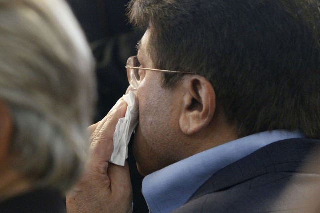Former Pakistani President Pervez Musharraf wipes his face after a shoe was thrown at him as he headed to court to face legal charges in Karachi,