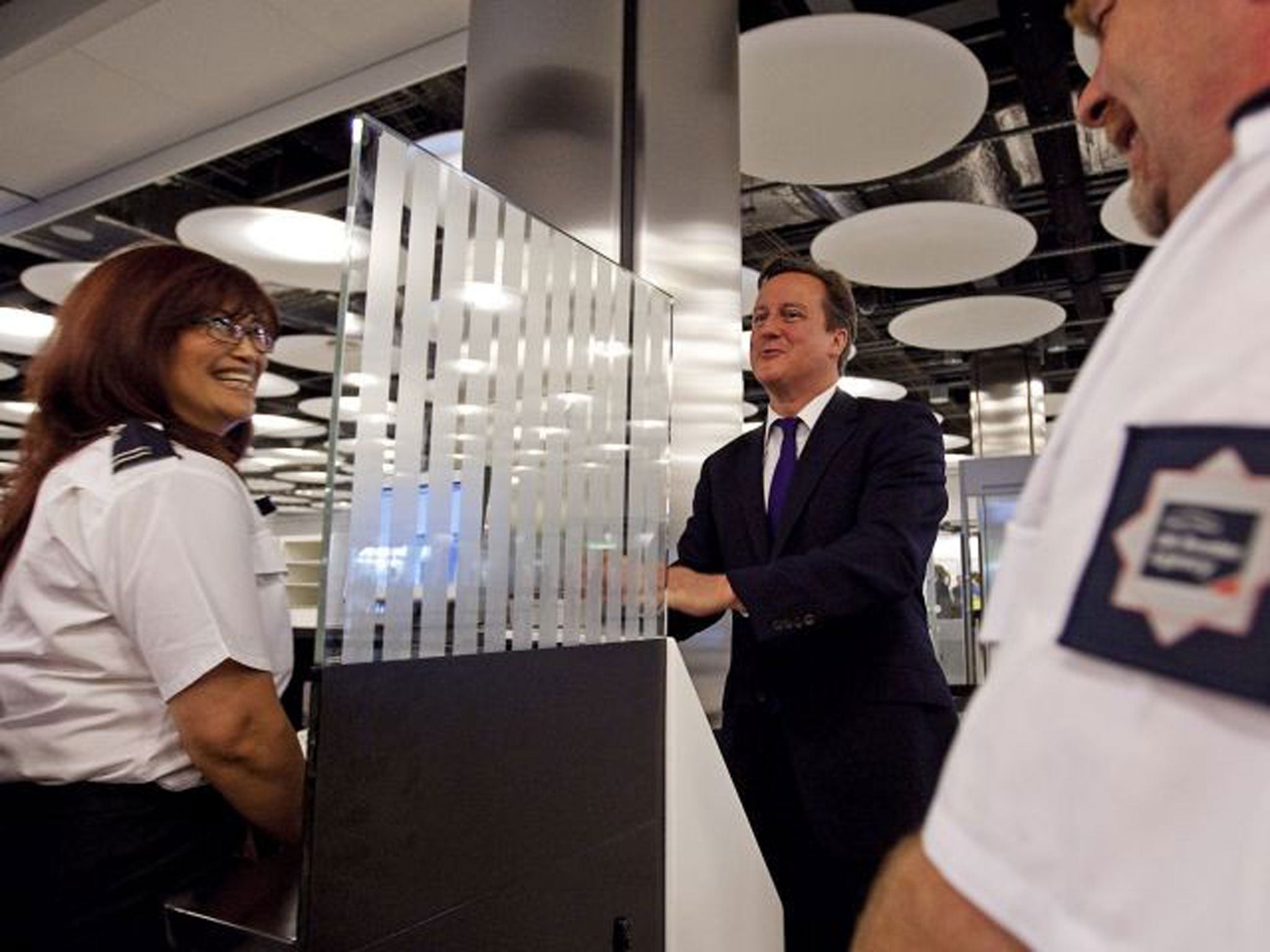 David Cameron with a UK Border Agency official at Heathrow