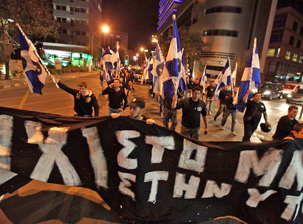 Members of the nationalist Cypriot party Elam (National Popular Front) march with a banner during a protest against the measures imposed on the banking sector