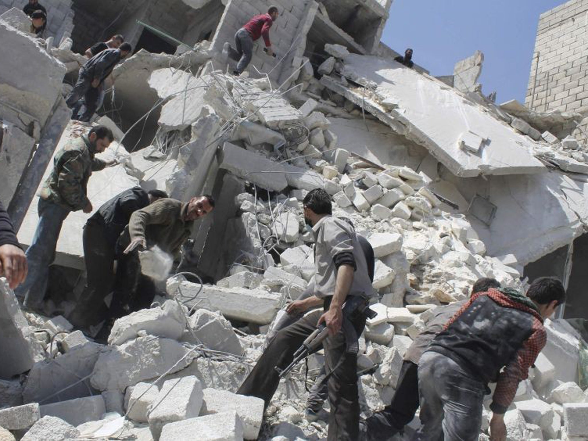 People search for casualties under the rubble at a site hit by what activists say was an air strike in Daiaat Al-Ansari neighborhood, Aleppo, on Saturday