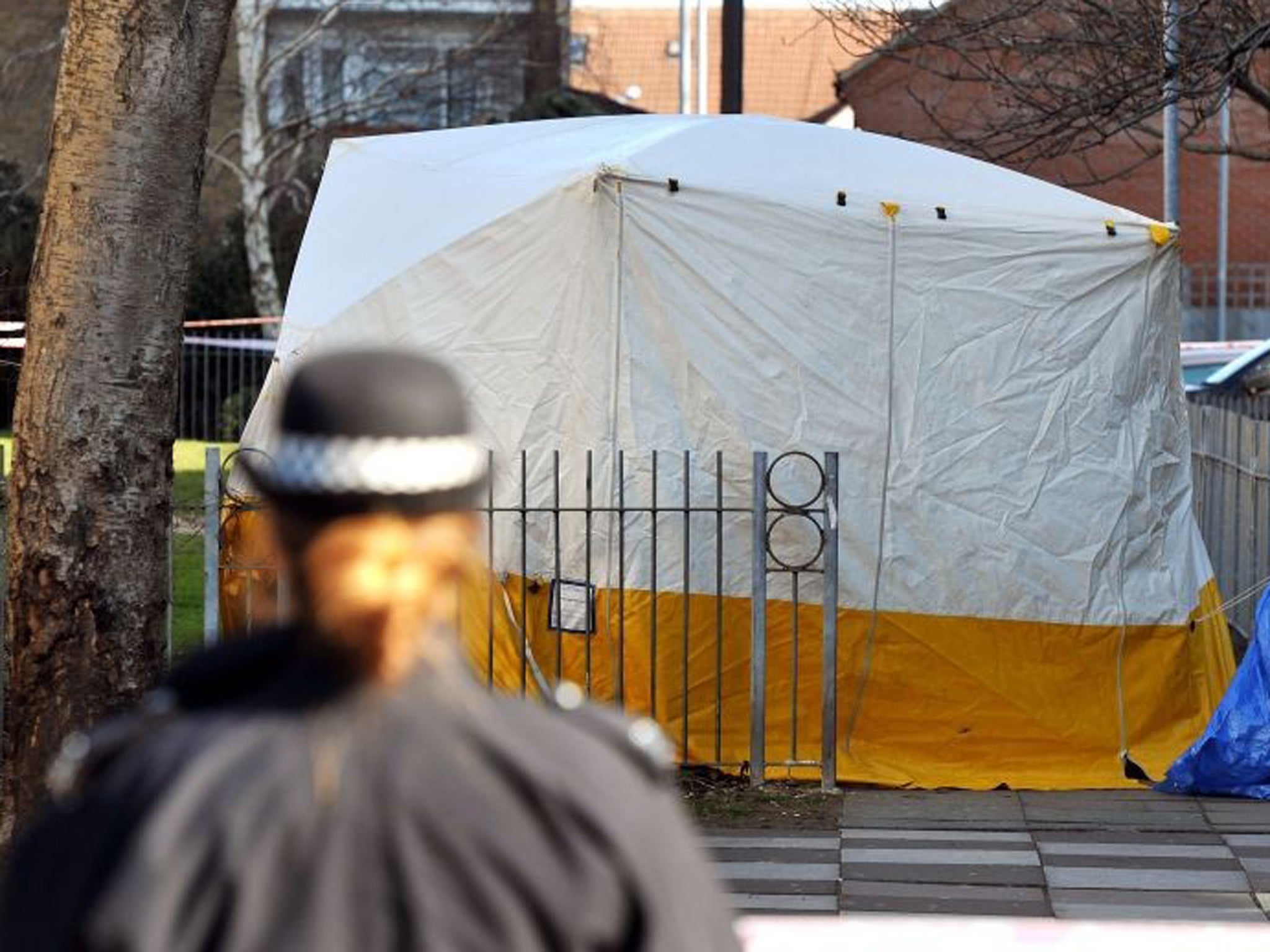 A police officer stands near a scene-of-crime tent after a 19-year-old man died after he was found injured in Bounces Road, Edmonton, following reports of shots being fired, Scotland Yard said