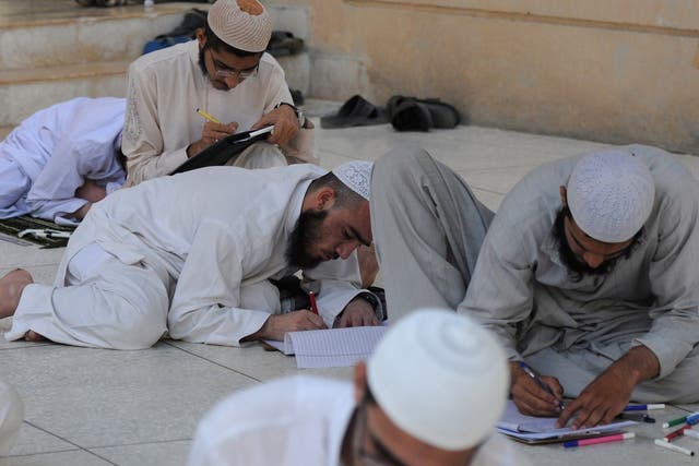 Pakistani youths take exams at an Islamic seminary in Karachi