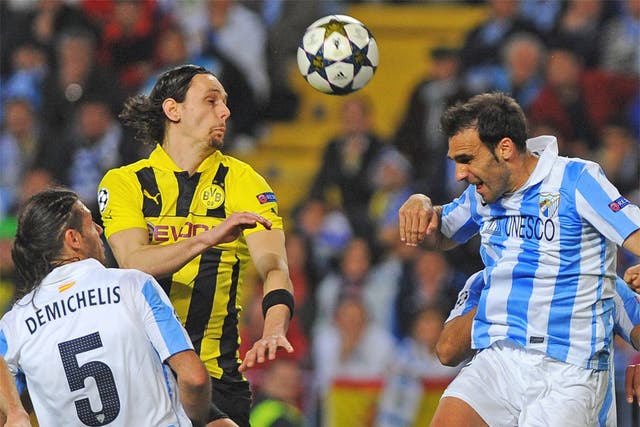 Dortmund's Neven Subotic vies with Malaga's Jesus Gamez in the first leg